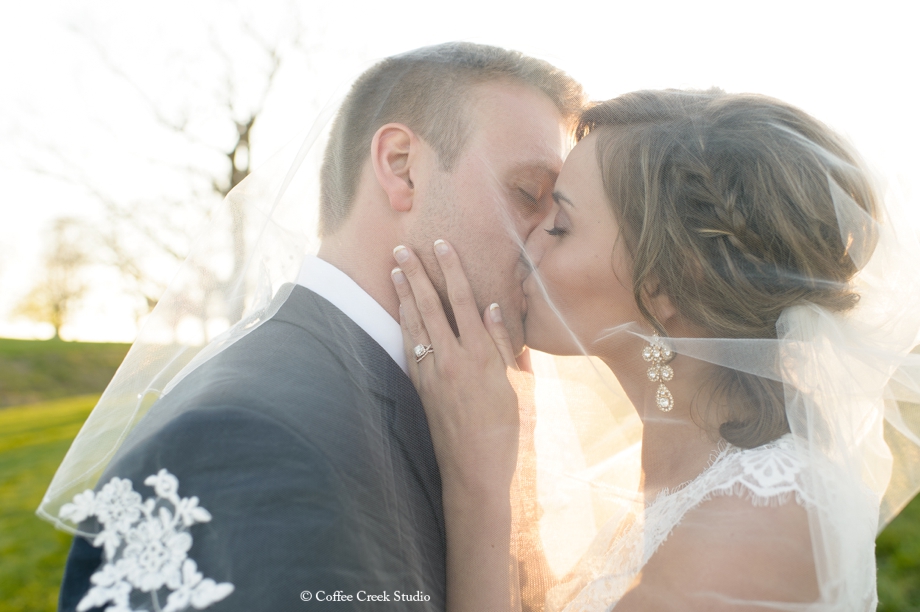 bride and groom portrait, kissing under veil