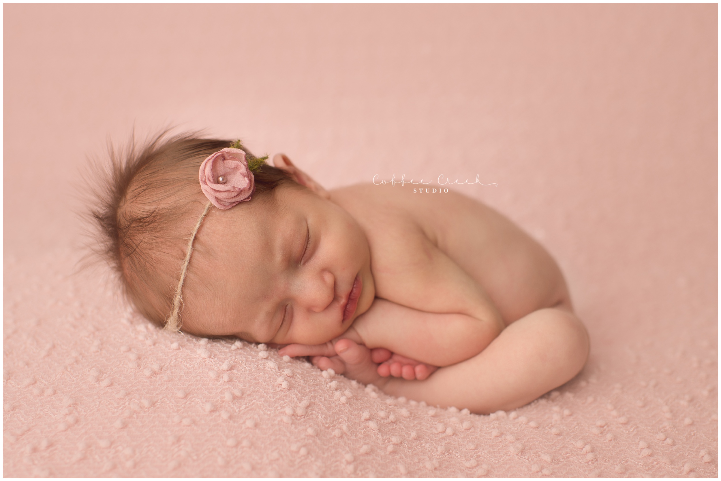 newborn girl on pink backdrop