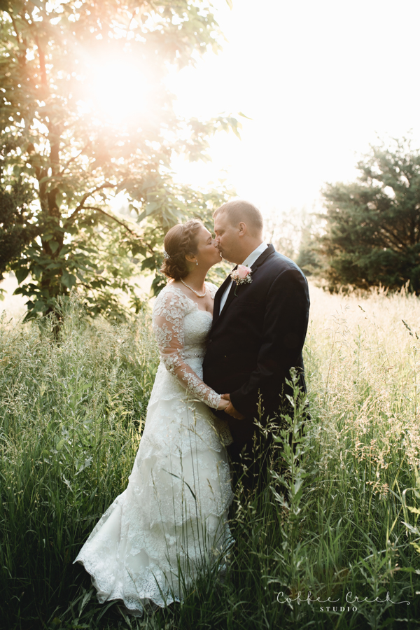 bride and groom kissing in tall wild grass