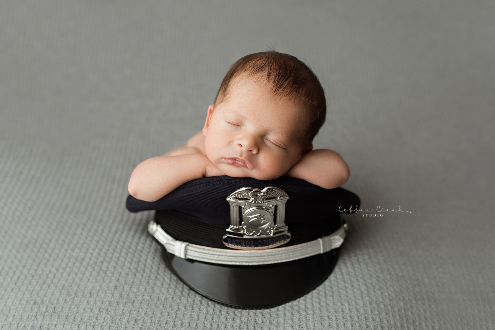 newborn baby boy on police officer hat